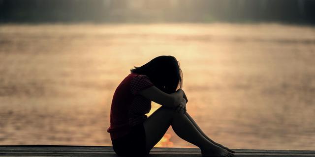 Femme en détresse sur la plage au bord de l'eau