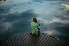 Femme en méditation devant une étendue d'eau