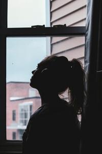 Femme pensive devant la fenêtre