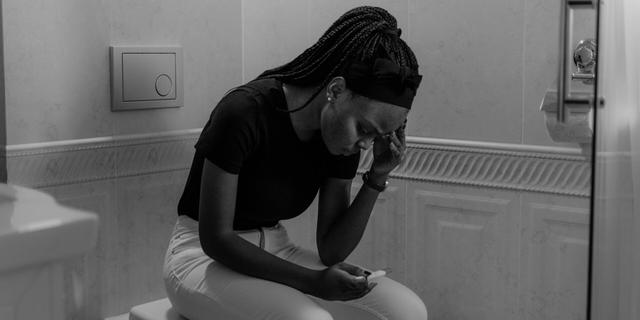 Femme découvrant son test de grossesse positif