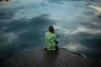 Femme en méditation devant une étendue d'eau