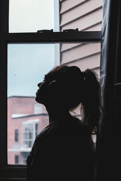 Femme pensive devant la fenêtre